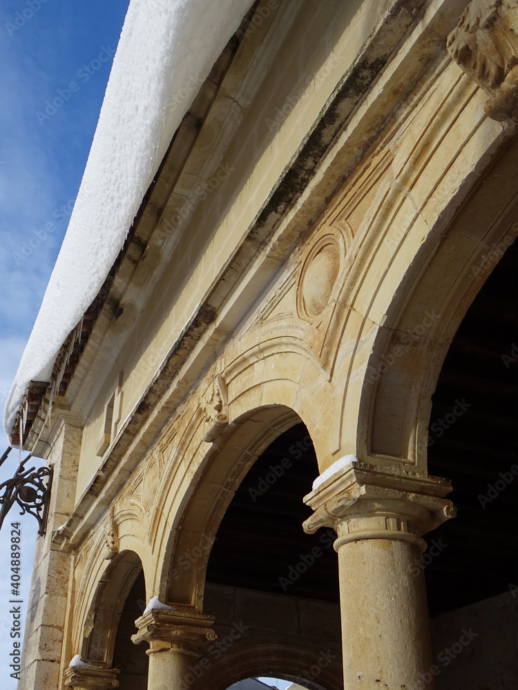 Renaissance arcade of the church of Azuqueca de Henares with snow on the roof during winter. Spain.  