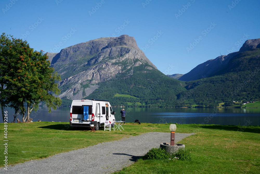 Wohnmobil auf einem sehr schönen Campingplatz mit Bergen in Hintergrund und See