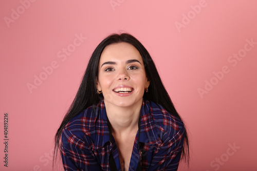 Emotions on the face of beautiful young woman on pink background © Сергей Луговский