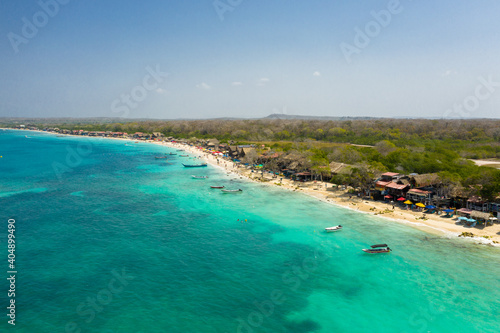 Beautiful tropical sandy exotic emerald paradise beach with sunbeds and sun umbrellas aerial view.