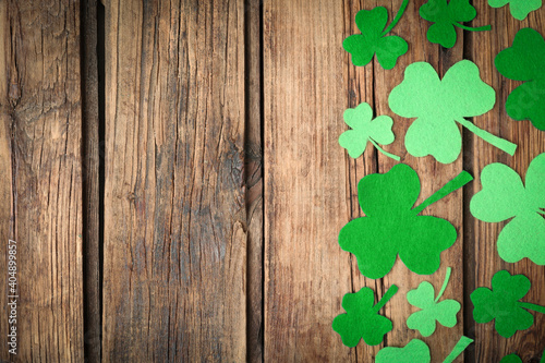Decorative clover leaves on wooden background, flat lay with space for text. St. Patrick's Day celebration