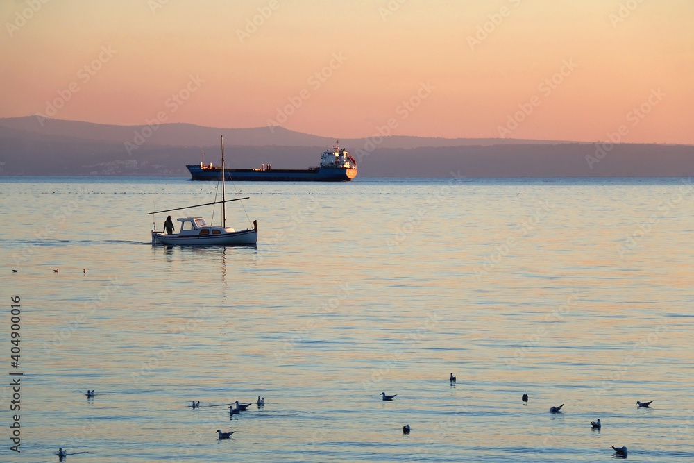 Flock of seagulls and boat during beautiful sunset. Landscape in Split, Croatia. Flock of seagulls and boat during beautiful sunset. Landscape in Split, Croatia.