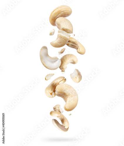 Crushed cashew nuts are falling down, isolated on white background photo