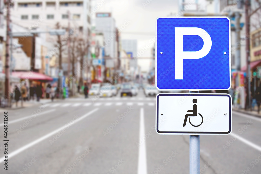 Disabled Parking sign over blurred street city background. Disabled Parking sign over blurred street city background.