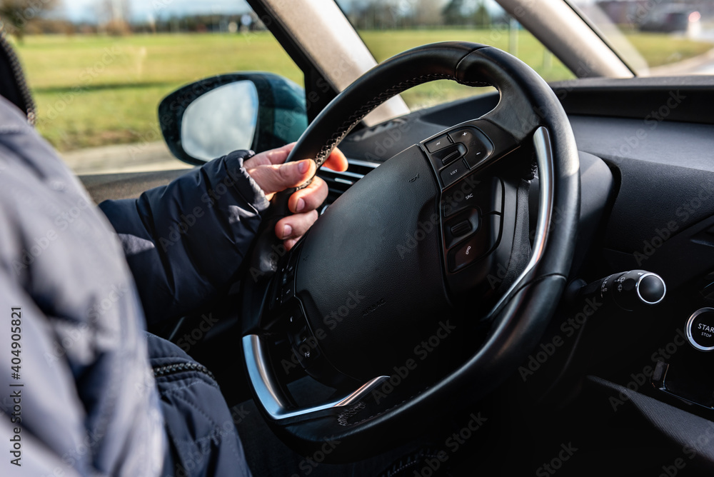 Driving a car. A man sitting behind the wheel of a car and holding the wheel. Driving a car. A man sitting behind the wheel of a car and holding the wheel.