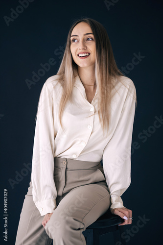 Photos Fashion model seating chair in dress pants and white shirt
