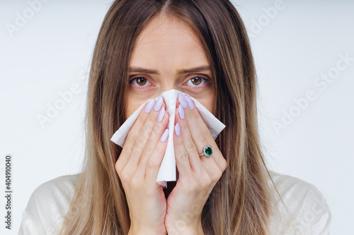 Young sick girl in white shirt sneeze holding tissue handkerchie