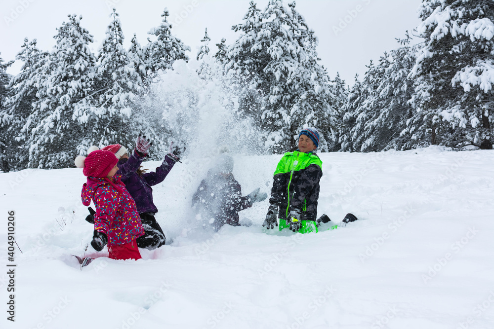 Group of children playing on snow in winter time. 