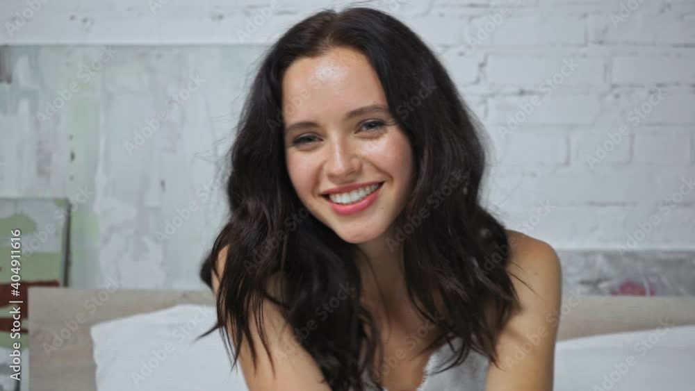 cheerful young woman smiling while looking at camera cheerful young woman smiling while looking at camera