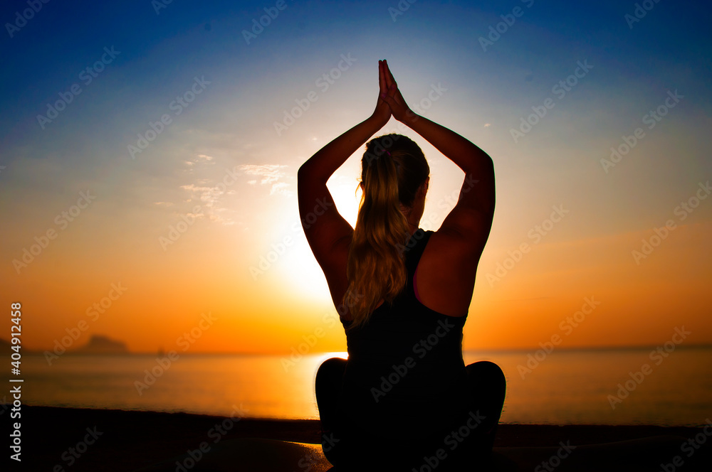 Silhouette of female athlete on sunset/sunrise seaside background, concept of endurance, strength, healthy lifestyle
