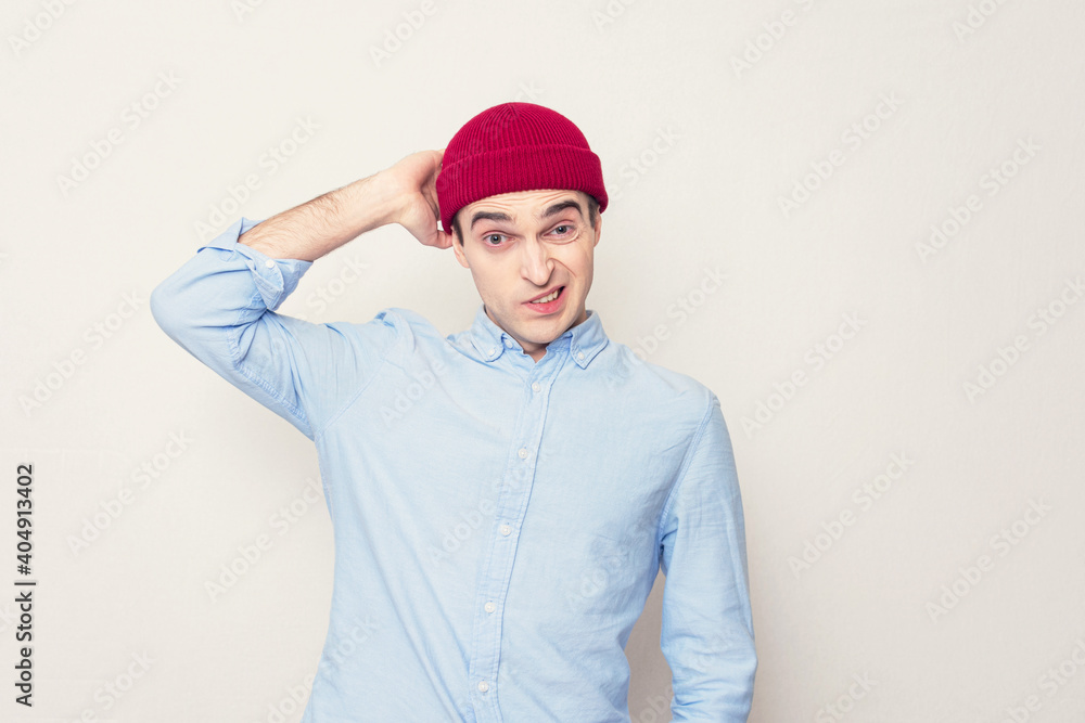 Puzzled guy in a red cap looks at the camera, portrait Puzzled guy in a red cap looks at the camera, portrait