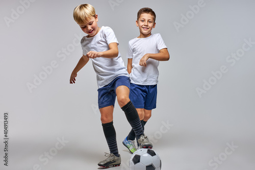 two boys playing soccer, enjoying sports game, kids in sportive uniform having fun, kids activities, little soccer player. isolated photo