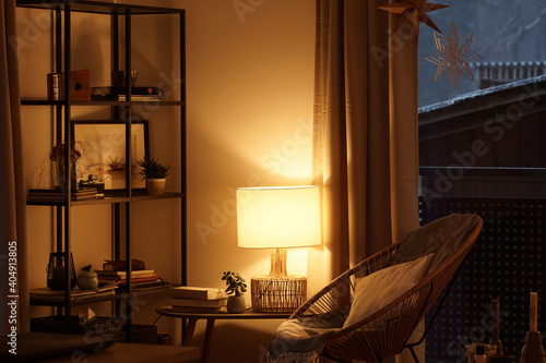 View of a cozy reader's corner with a table lamp spending warm light © Thomas