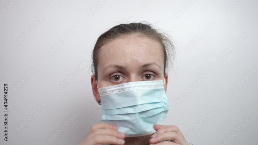 Girl puts on a medical mask, white background Girl puts on a medical mask, white background