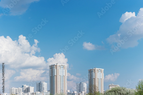 Apartment buildings. Blue sky with fluffy clouds, copy space