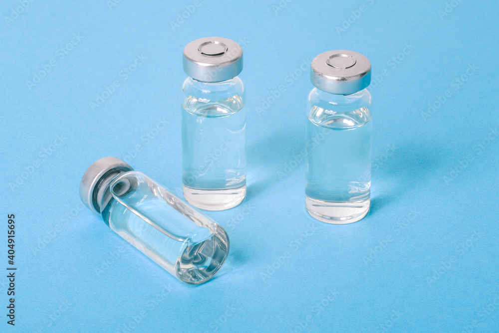 Covid-19 vaccine close-up. Glass vials with liquid. Treatment of infections and diseases Covid-19 vaccine close-up. Glass vials with liquid. Treatment of infections and diseases