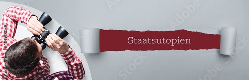 Staatsutopien. Mann (Anwalt) bei Beobachtung mit Fernglas. Fokus auf Text/Wort in einem Papier Riss. photo