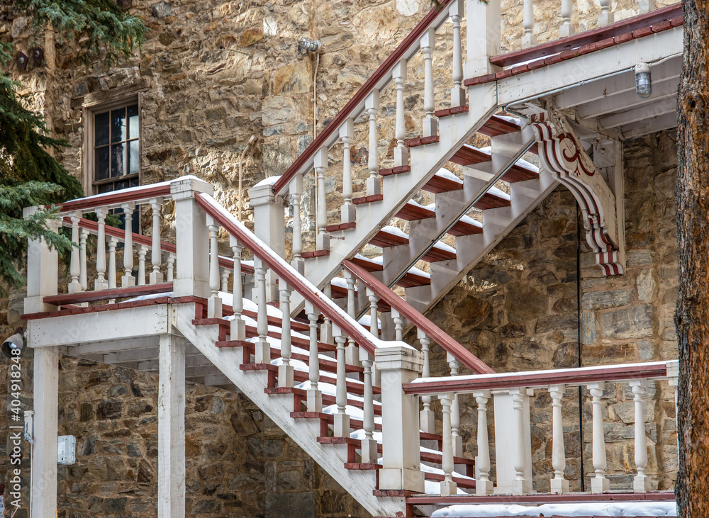 Φωτογραφία The wall of an old brick building with a door and a beautiful wooden staircase i