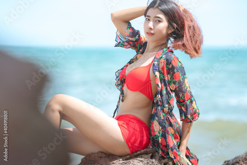 Cute young asian woman in bikini happy on beautiful beach in summer vacation in Thailand