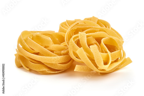Raw tagliatelle pasta, close-up, isolated on white background