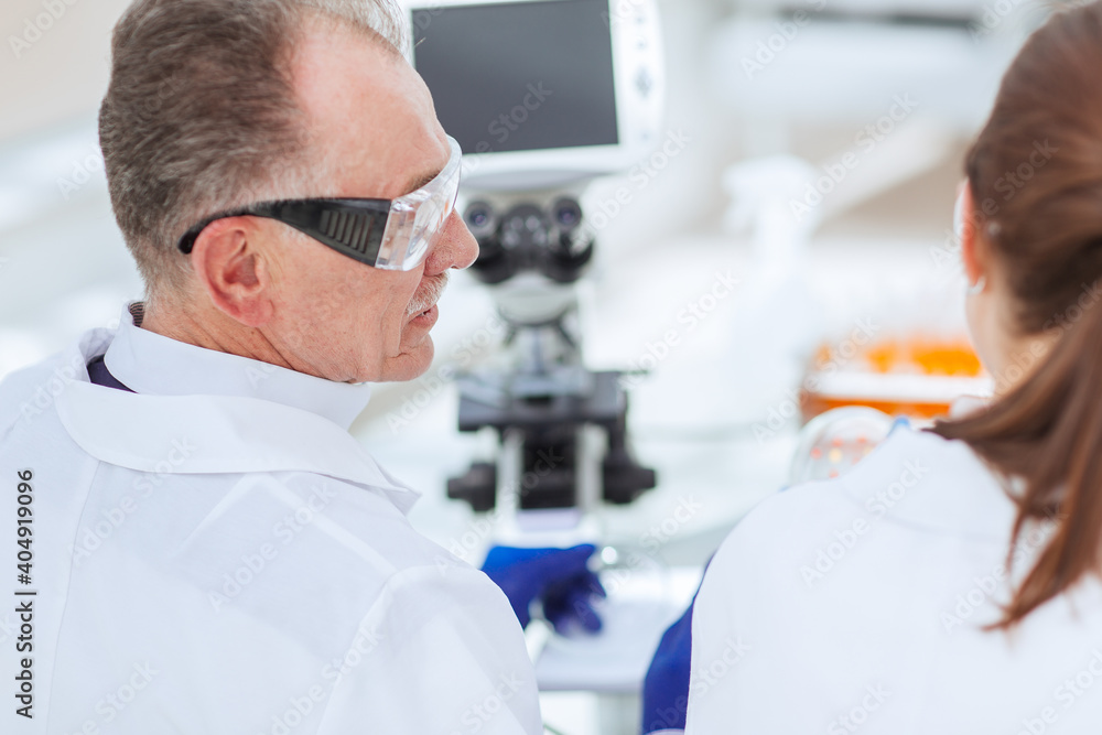 rear view. scientists talk sitting at a laboratory table. rear view. scientists talk sitting at a laboratory table.
