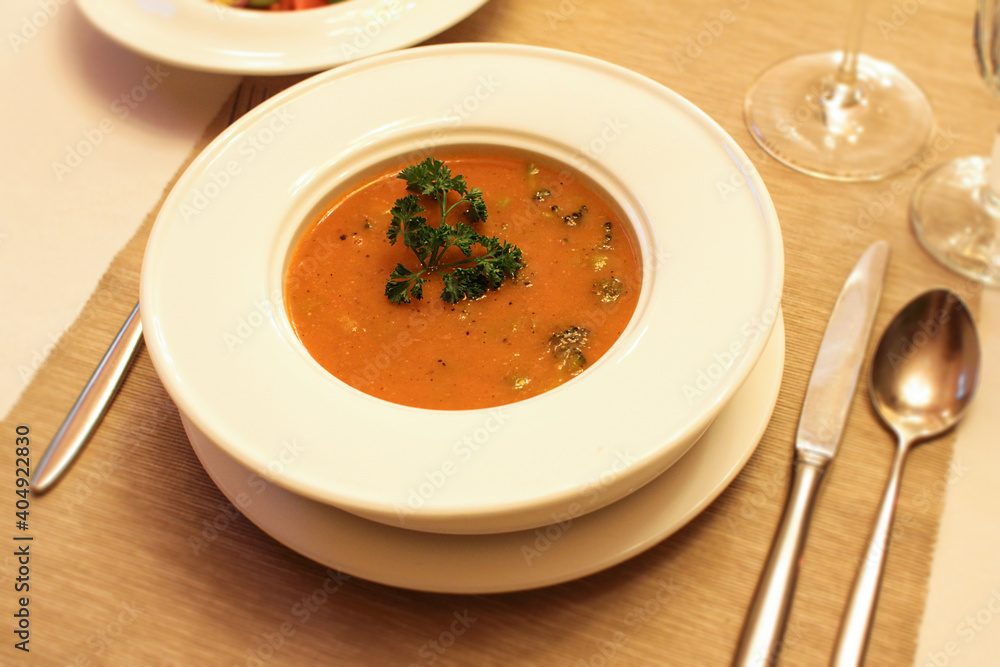 Lentil and broccoli puree soup in white plate served on table in restaurant. Lentil and broccoli puree soup in white plate served on table in restaurant.