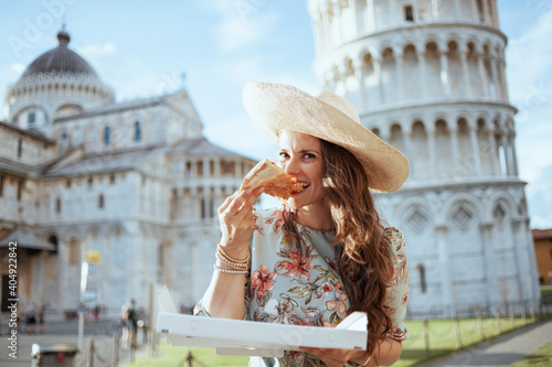 smiling stylish woman in floral dress with pizza and hat