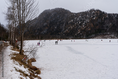 Eisstock Spieler und Eisläufer auf dem zugefrorenen Almsee in Oberösterreich