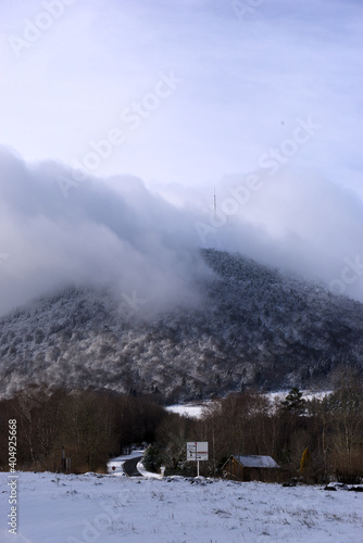 Panoramic view of the snowy Puy-de-Dome, hanging the clouds. Col de Ceyssat, Auvergne
