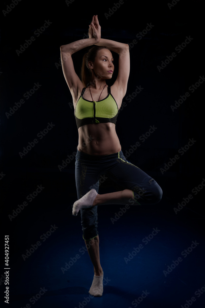 yogi girl standing on one leg holding her hands above her head