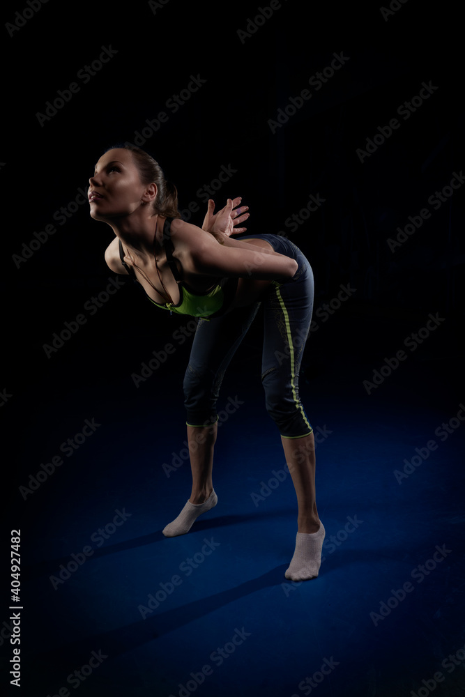 yogi girl leaned forward standing on socks and put her hands behind her back