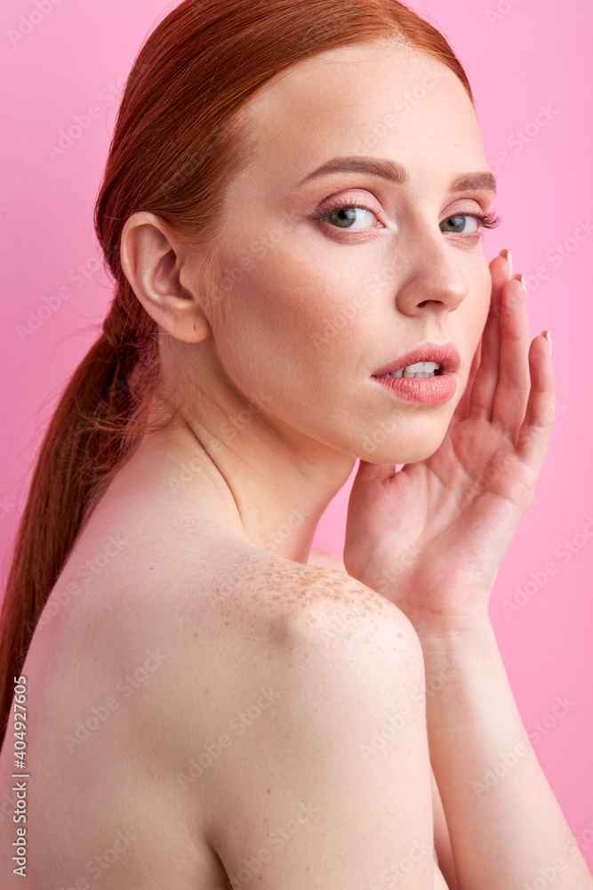 woman touching face isolated on pink, freckled woman posing at camera, people and beauty concept