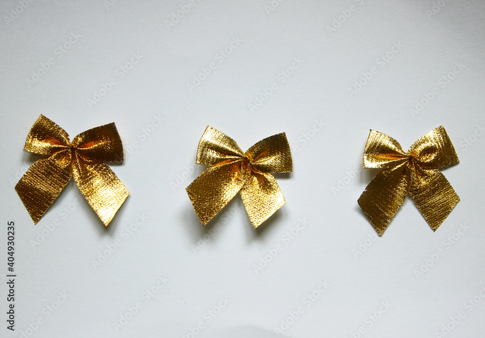 Set of three festive golden glossy gift bows on white background.