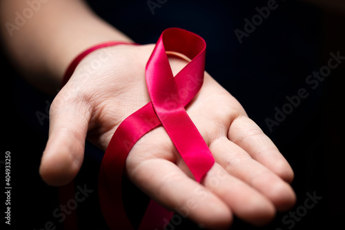 Wallpaper Mural Red ribbon in woman hands on dark background for World AIDS Day concept Torontodigital.ca