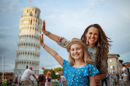 Tela happy mom and child posing at Leaning Tower in Pisa, Italy