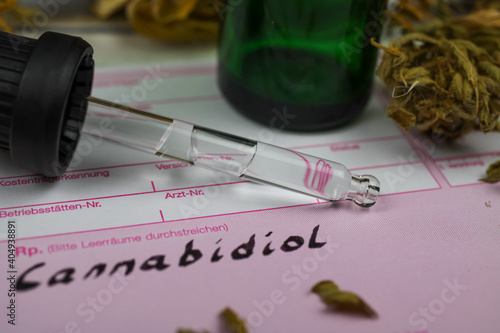 Macro close up of cannabidiol oil panel prescription form with bottle, pipette and dried cannabis leaves photo