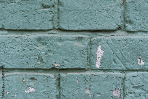Old scratched and dirty brick wall painted with aquamarine color. Textured background of vintage brick wall. Panoramic view of empty wall, can be used for design. © yevhen89