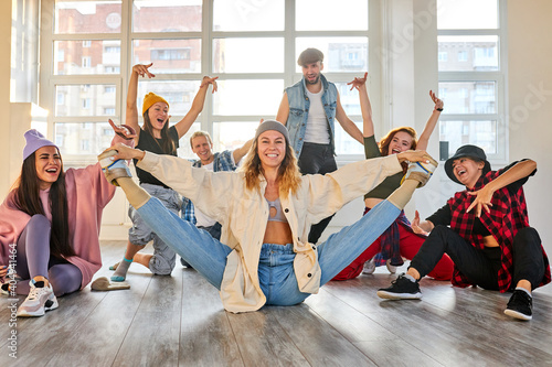 Valokuva group of young dancers performing a common choreography in modern dance studio,
