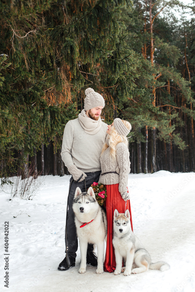 Lovers on a walk with the dog Husky in winter forest Lovers on a walk with the dog Husky in winter forest