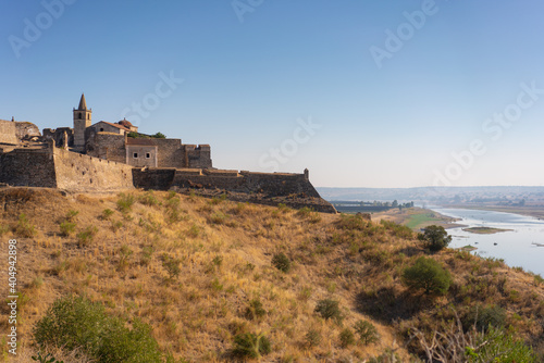 Juromenha castle and Guadiana river and border with Spain on the side of the river at sunrise, in Portugal © Luis