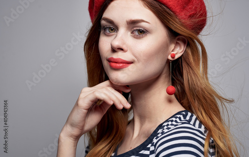 Portrait of a romantic woman in a bright makeup beret earrings striped T-shirt