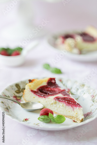 A piece of cheesecake with raspberries