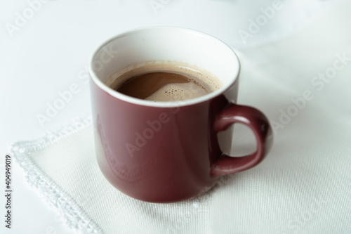 Taza de café con granos de café sobre fondo blanco.
