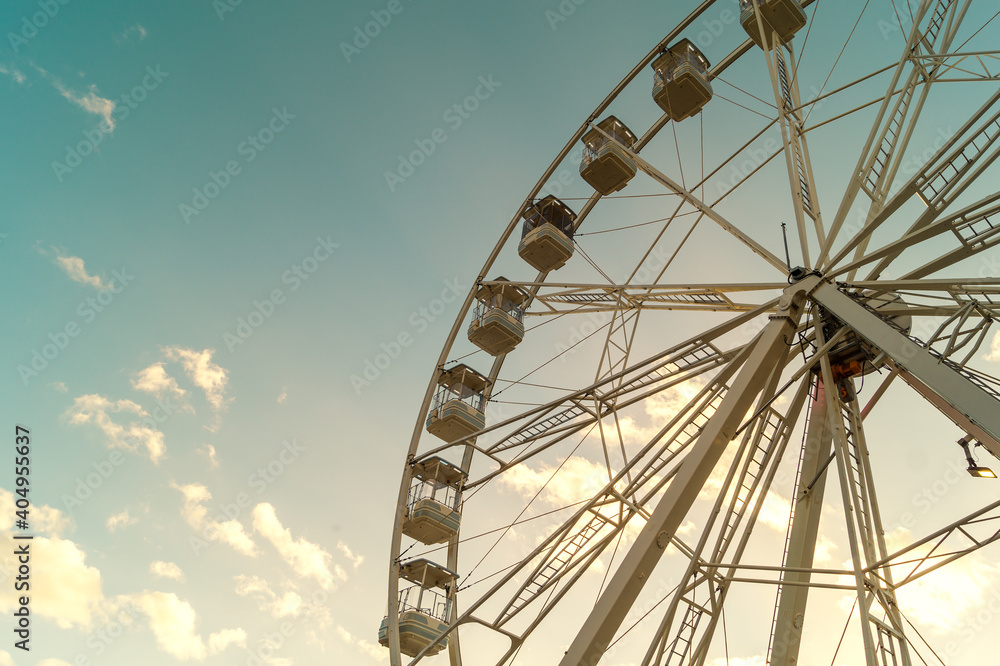 View from below of a large ferris wheel in a beautiful sunset.