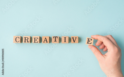 Creativity concept. Pov close up view photo of female person hand holding putting wooden block in a row isolated pastel color backdrop