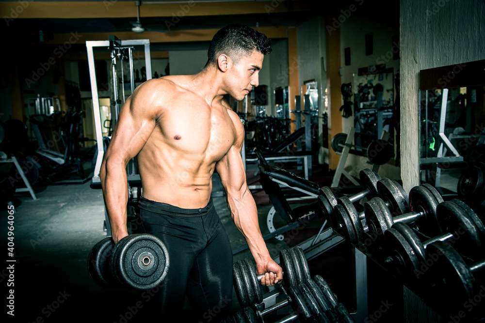 Young man exercising in dark and old gym Young man exercising in dark and old gym