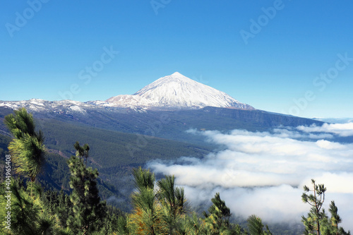 The Teide National Park on the volcanic island of Tenerife in winter with snow on the Teide. Viewpoint from "Corona Forestal" at an altitude of 1854 m. dark blue sky with sun and in the right from 