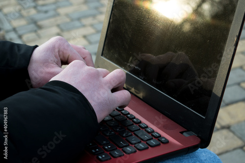 Man working at red laptop close up. Free space for text or picture