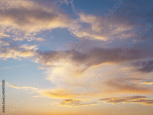 Clouds illuminated by sunset sunlight in the blue sky. Background texture. Fullscreen photo