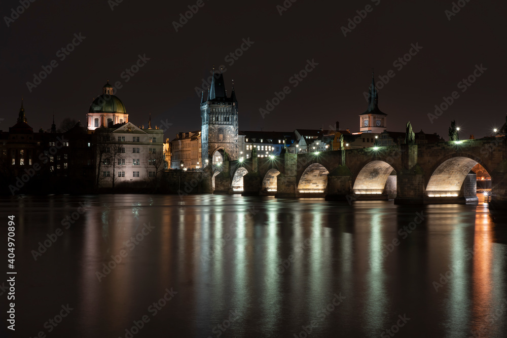 Fototapeta premium view of Charles Bridge on the river Vltava and light from street sovetleni at night in the center of Prague